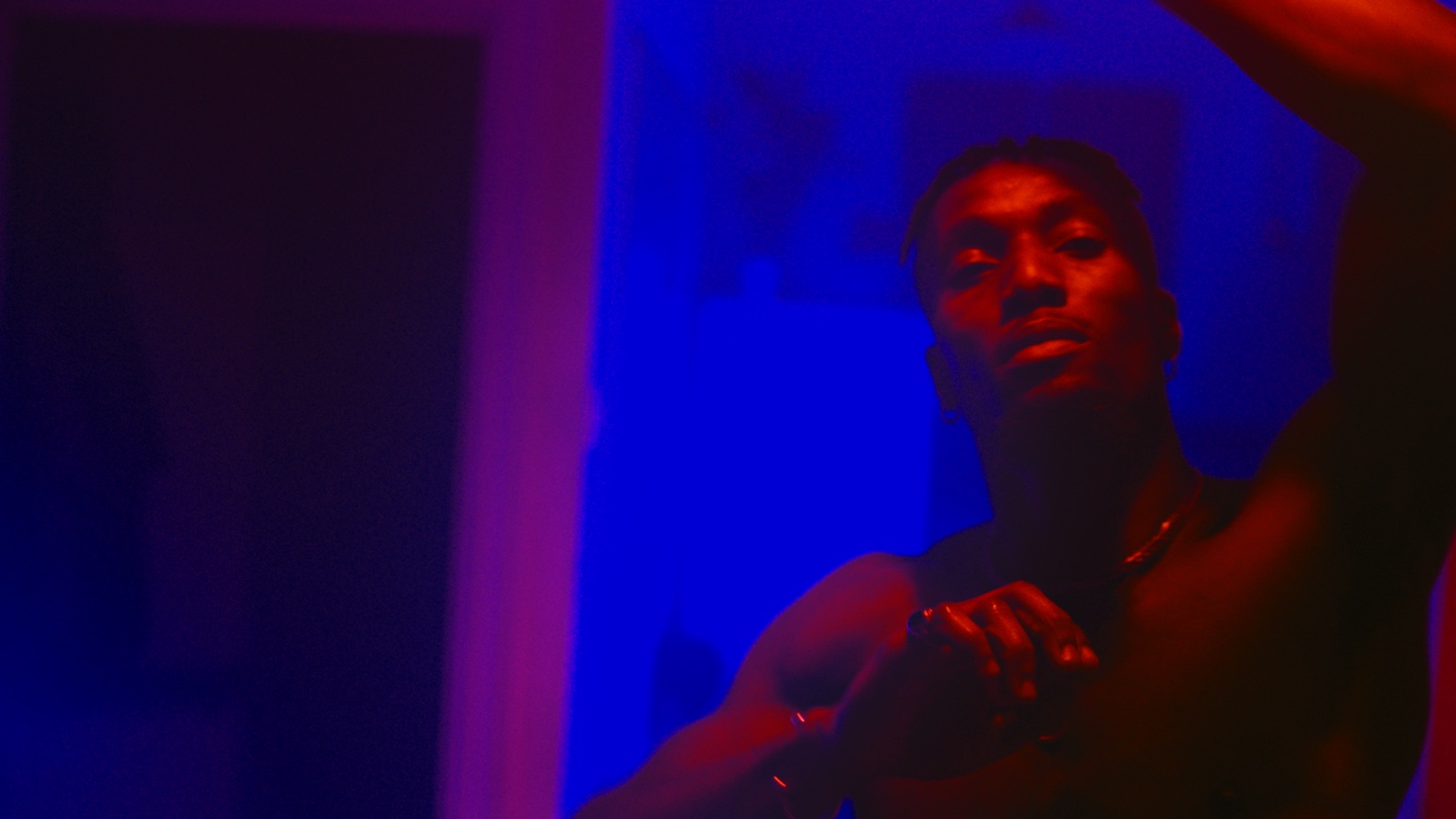 Performer lit in red against an electric blue background